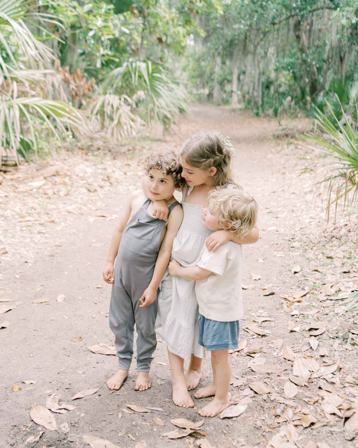 Three children hugging each other playfully by Savannah Family photographer Courtney Cronin