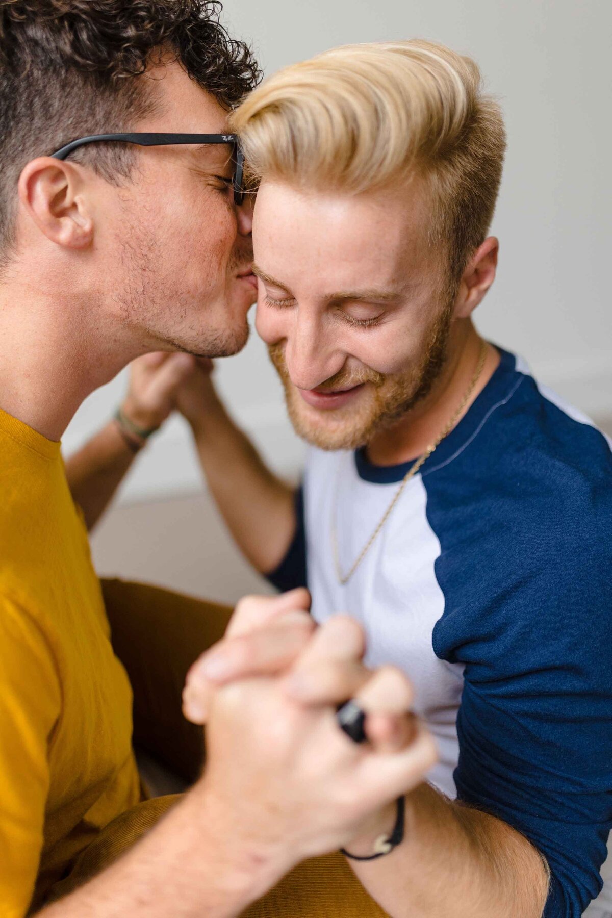 Gay male couple kissing on the cheek