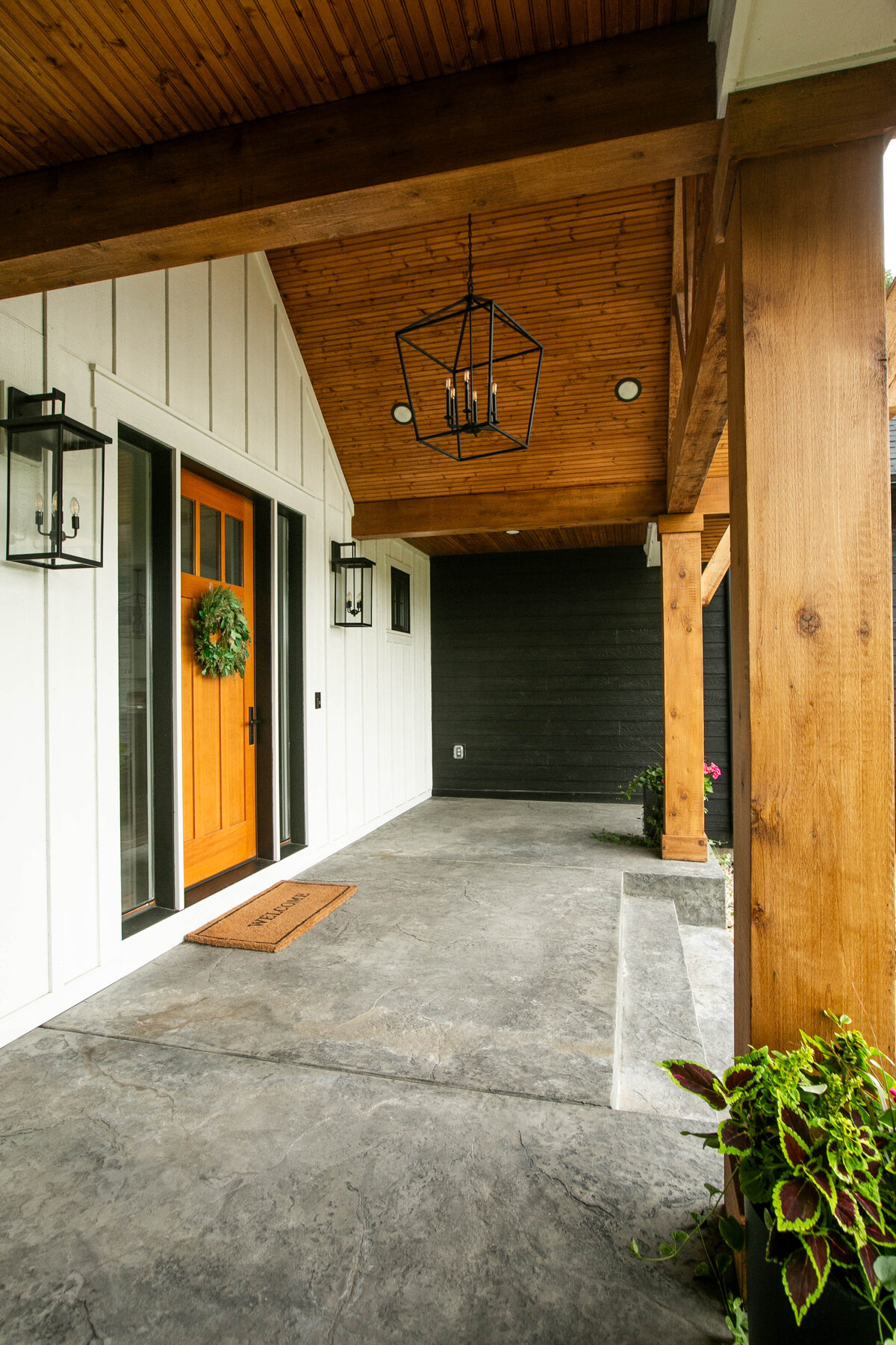 Exterior view of custom home in Otsego, Minnesota with modern wood details and front porch built by Cornerstone Custom Builds