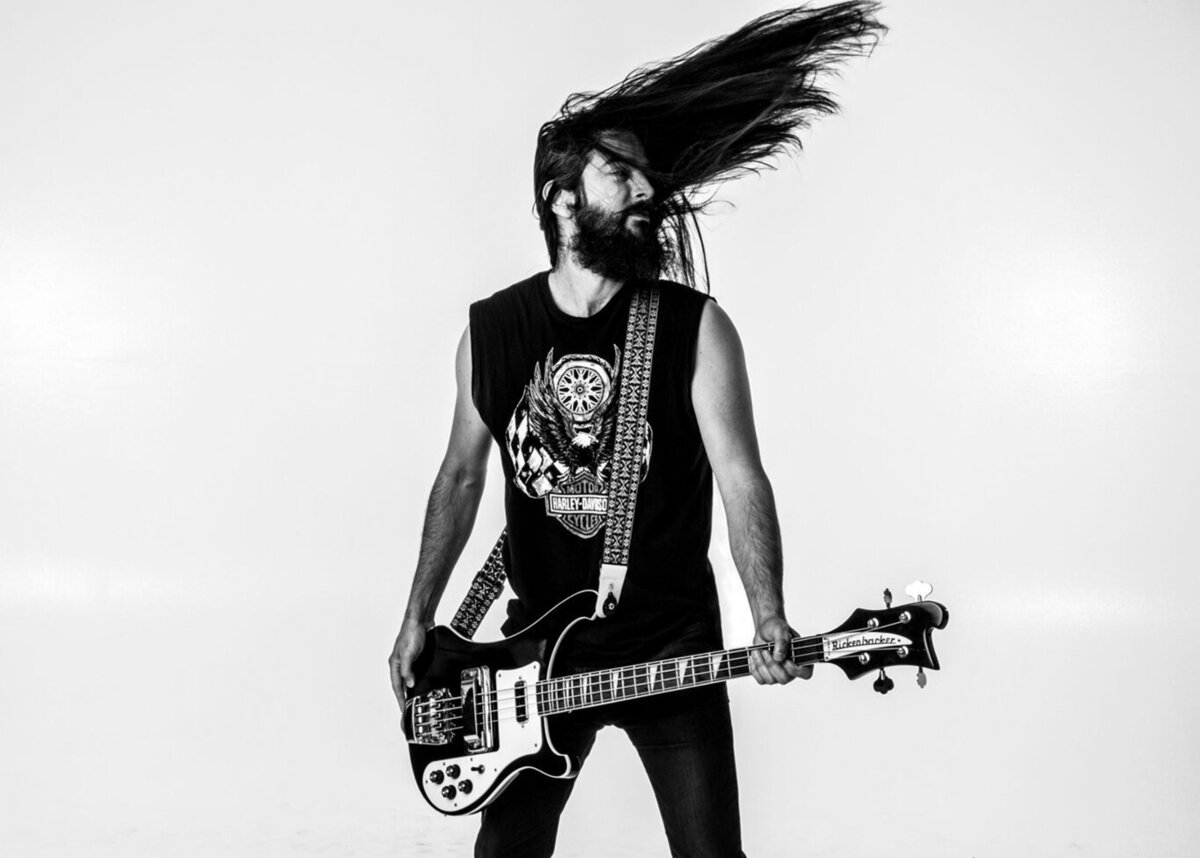 Musician photo Los Angeles Michael Dwyer black and white standing against white backdrop holding electric guitar flipping long hair Just Play Something Gallery
