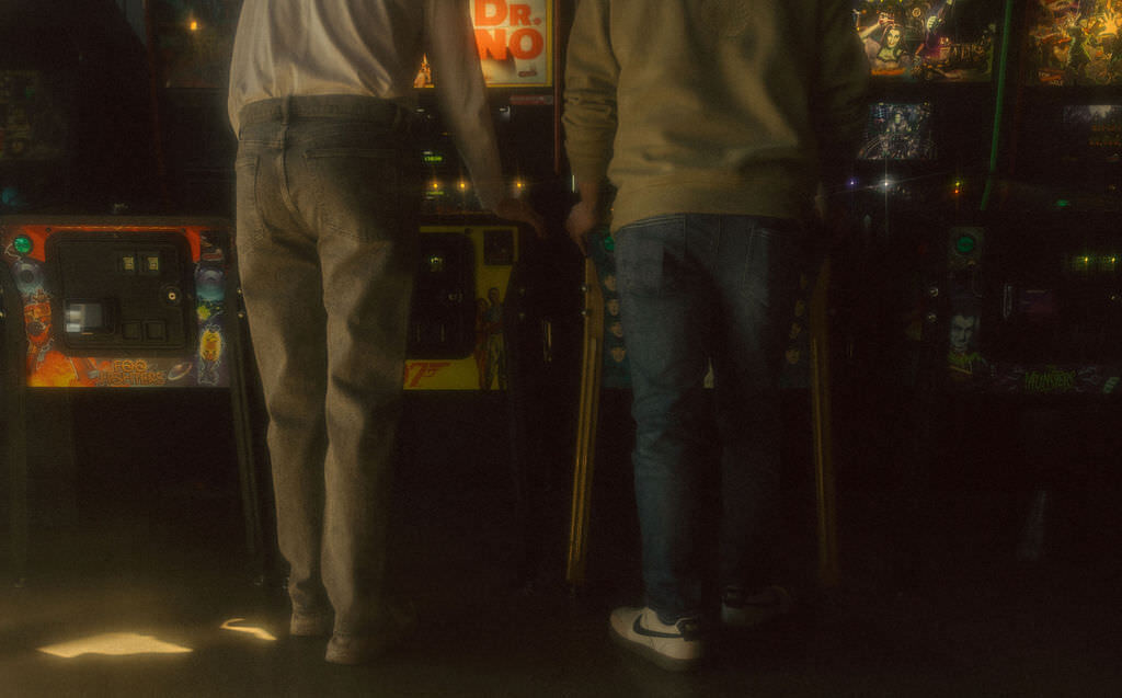 Two people playing pinball together.