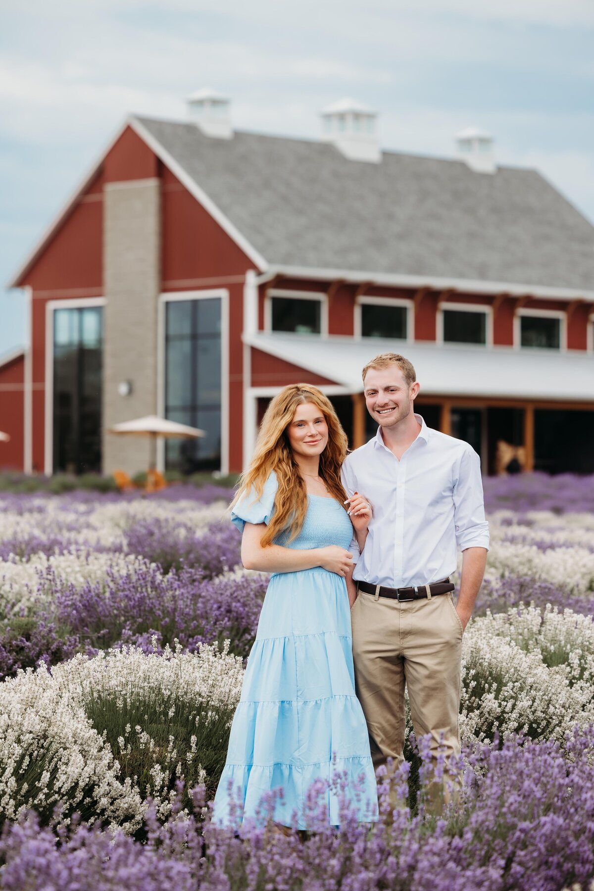 couple-standing-in-front-of-barn