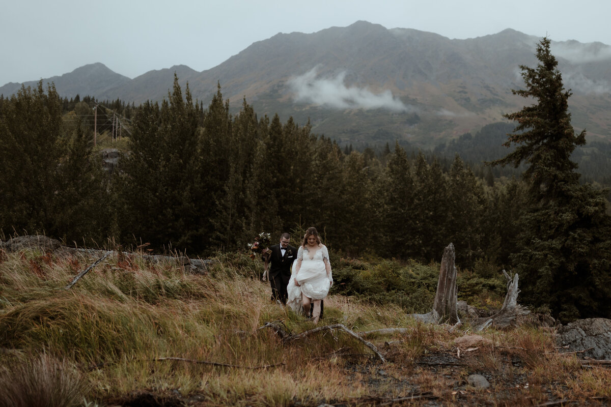 bride and groom walking on hillside
