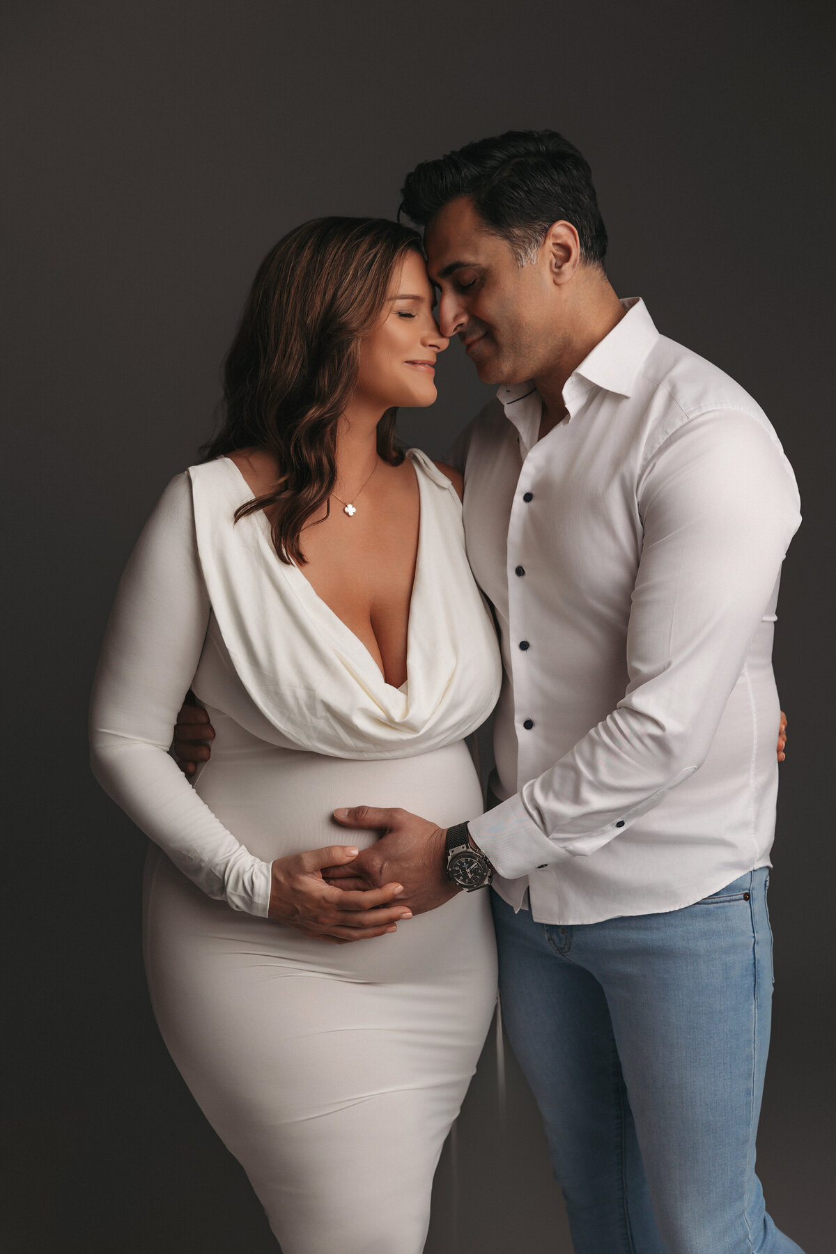couple posing for maternity portraits in phoenix maternity studio 