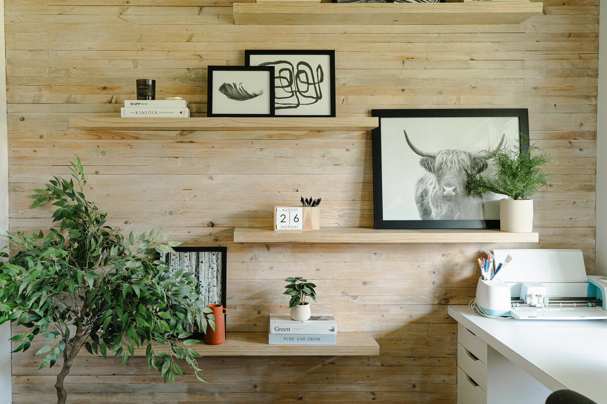 light wood wall with floating shelves in study