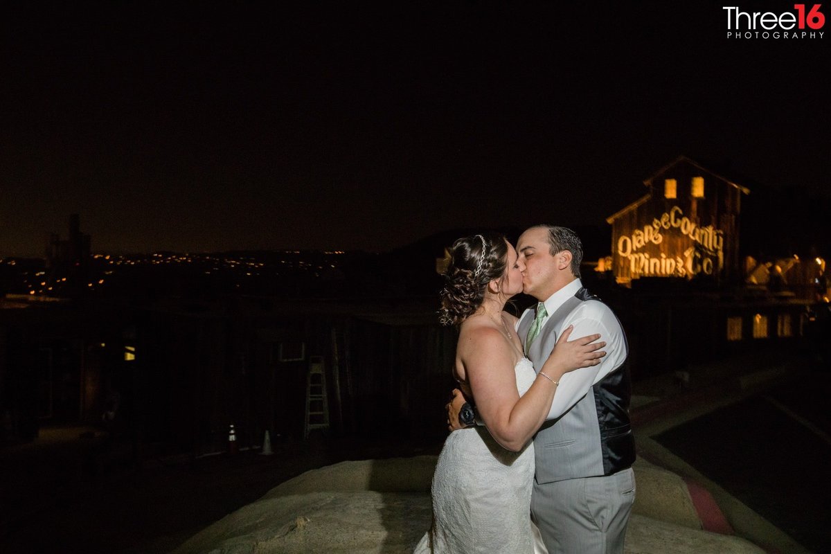 Bride and Groom share a quiet kiss outside at night