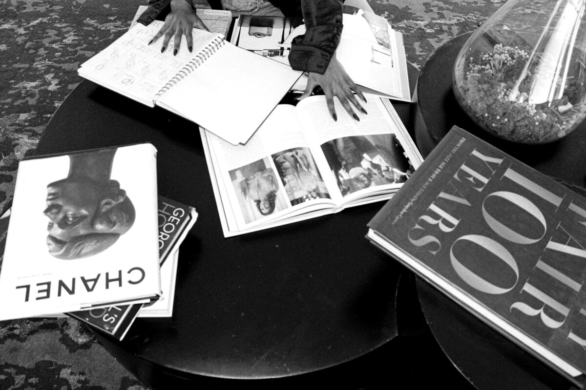 Chanel and designer books with African American woman hands.