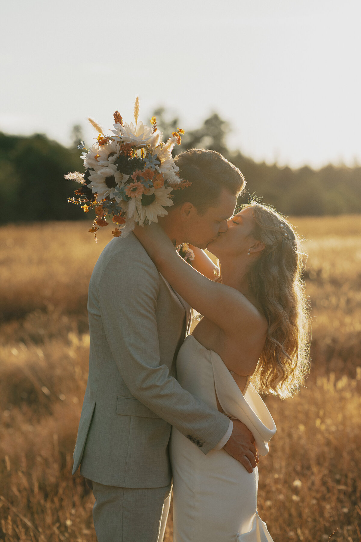 Bride and groom kissing at golden hour during wedding portraits in Comox by Latitude 49 Photography