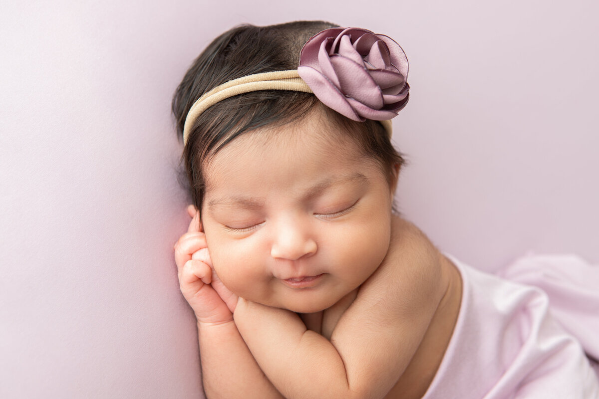 Studio table posed newborn on a lilac backdrop