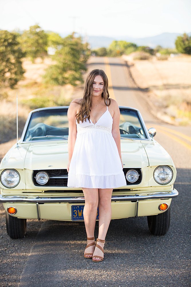 Senior girl in white dress with vintage car