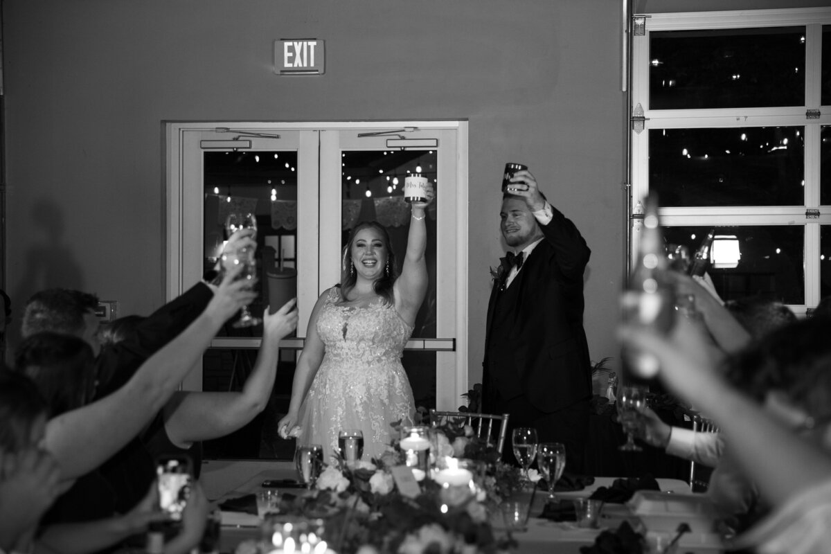 A bride and groom raising their glasses at their wedding reception captured by an Austin wedding photographer.