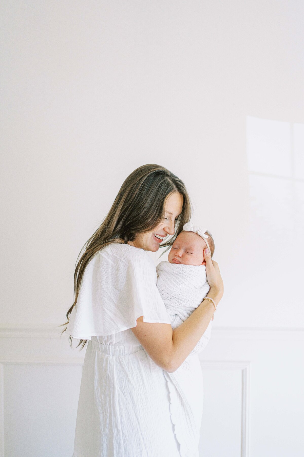 mom snuggling newborn baby girl