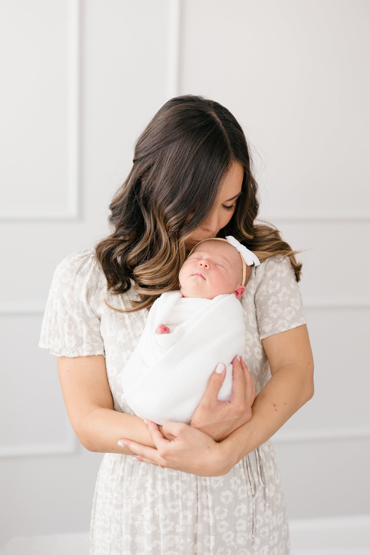 New mom cradling her sleeping newborn swaddled in white by Missy Marshall Louisville Photographer