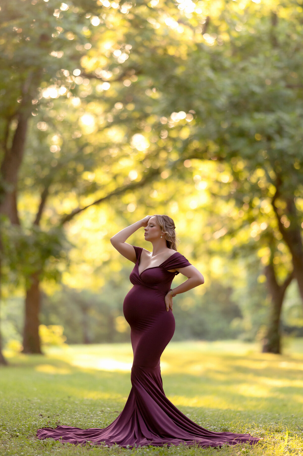 Golden hour maternity portrait in Round Rock with the mom-to-be standing confidently in a flowing purple dress under glowing trees.
