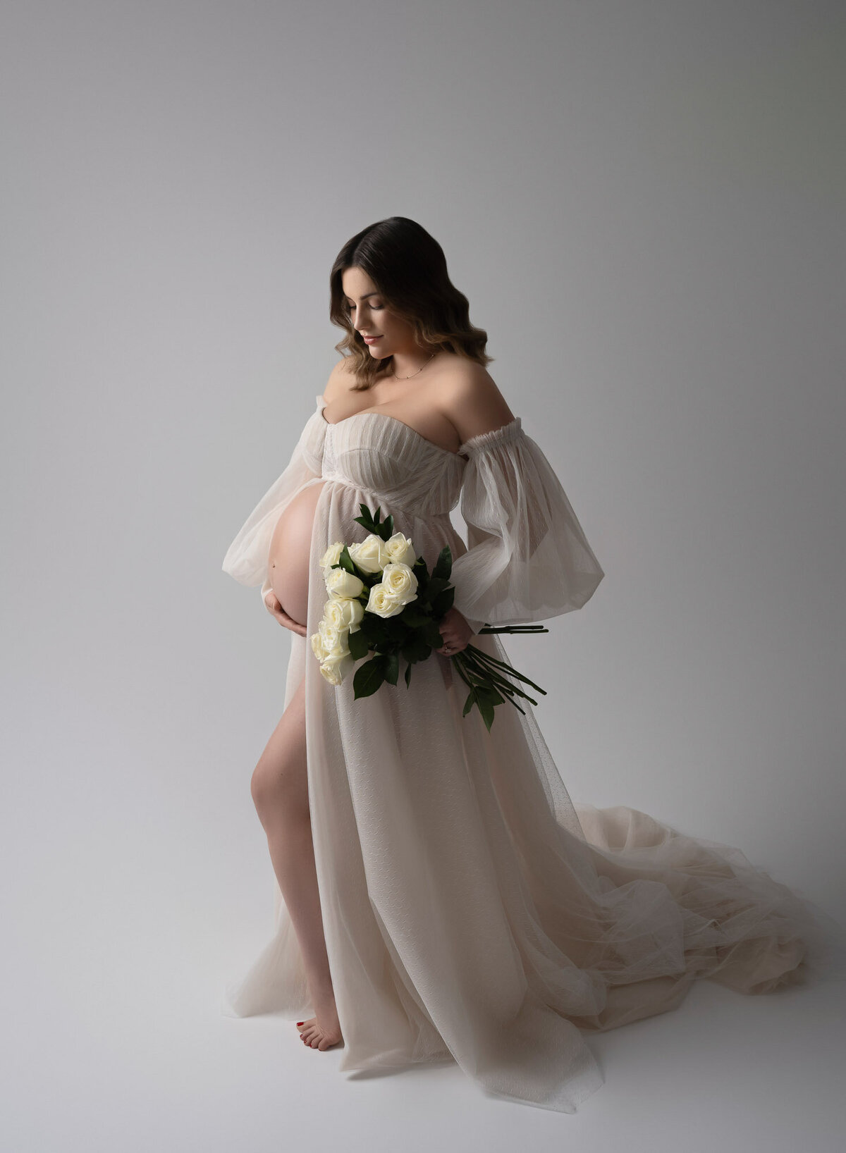 Artistic maternity photography showcasing natural pregnancy beauty in studio lighting