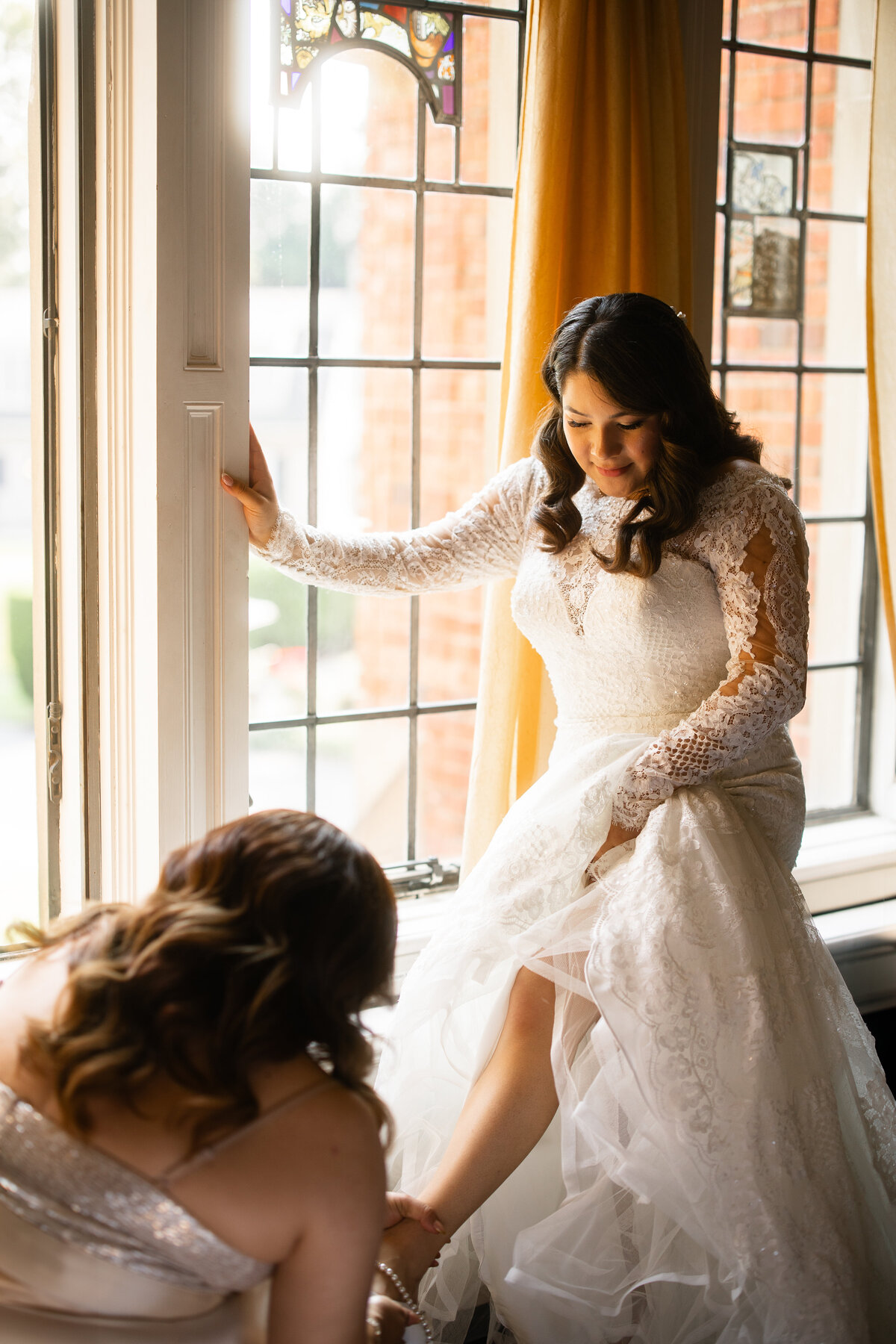 Bride and her mother helping her put on the veil