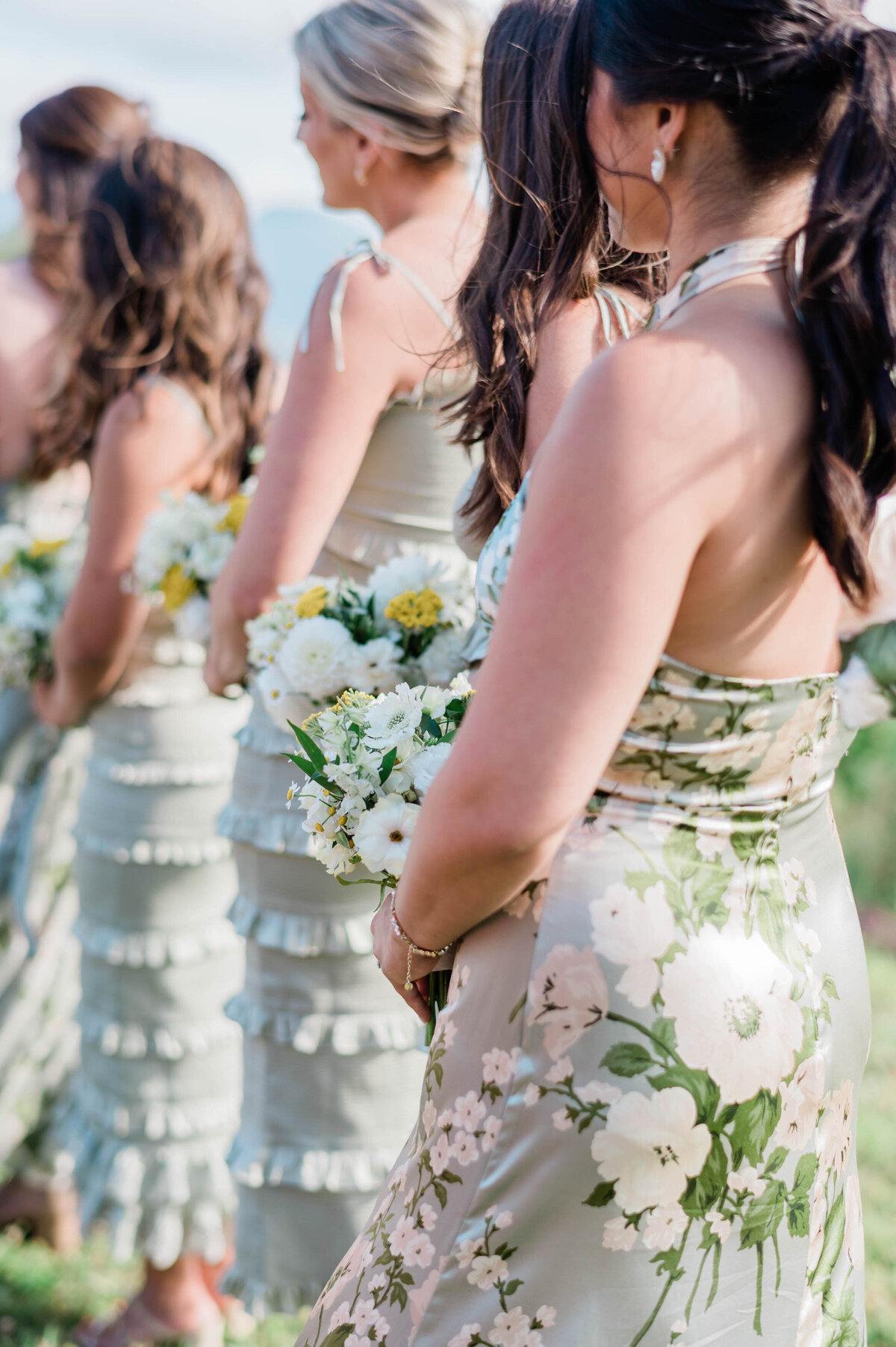 Bridesmaids stand in floral green dresses at the altar