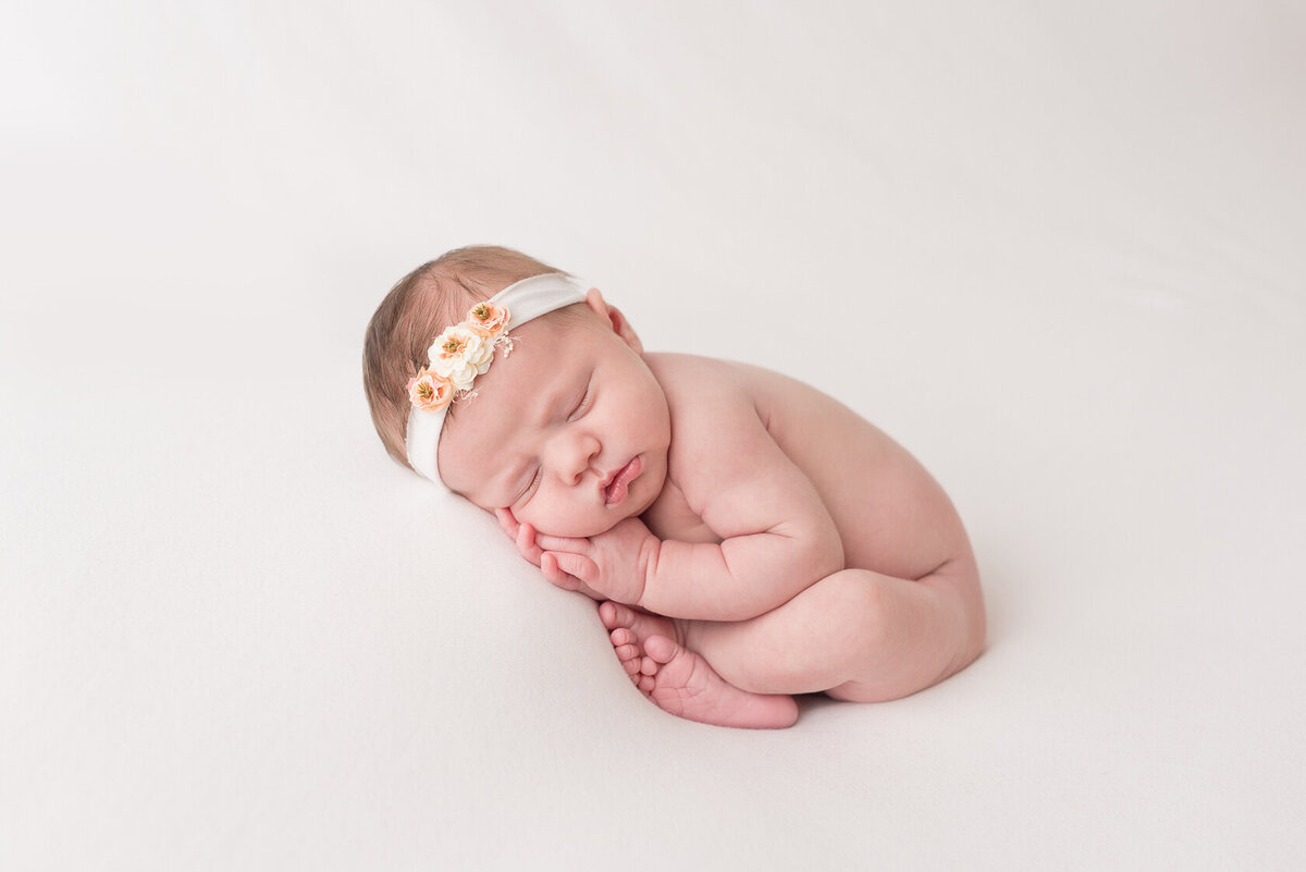 Sleeping newborn in white background photography by Laura King