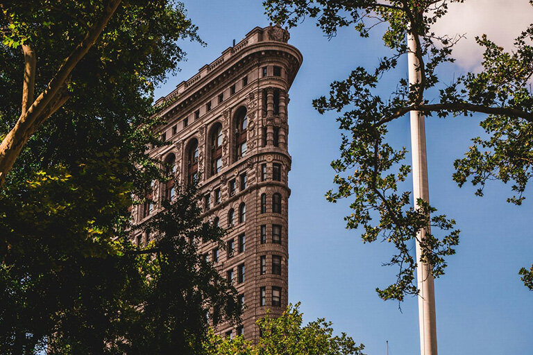 The iconic Flatiron Building in New York City, home to Flatiron Therapist, stands tall with its unique triangular shape.