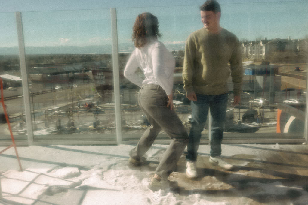 A couple standing on a rooftop deck together.