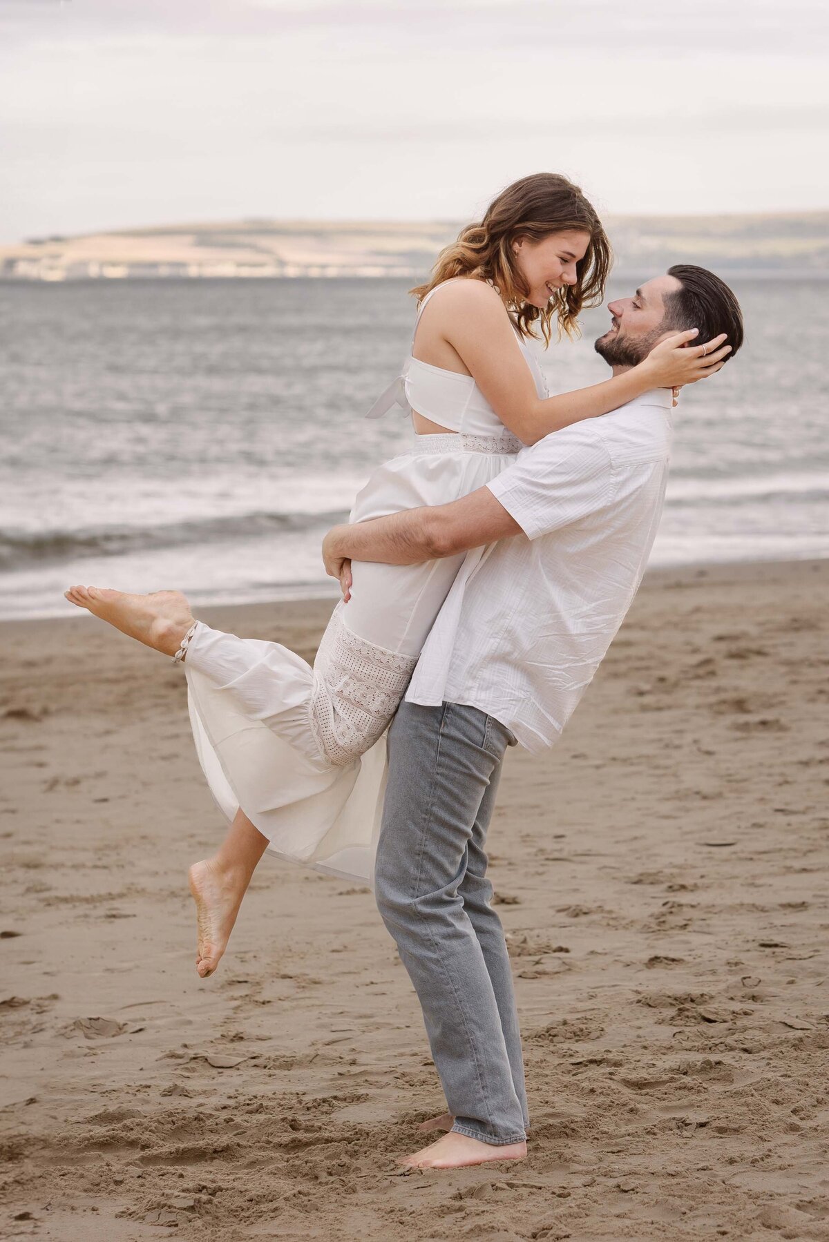 A couple hugging on a beach at sunset in Dorset