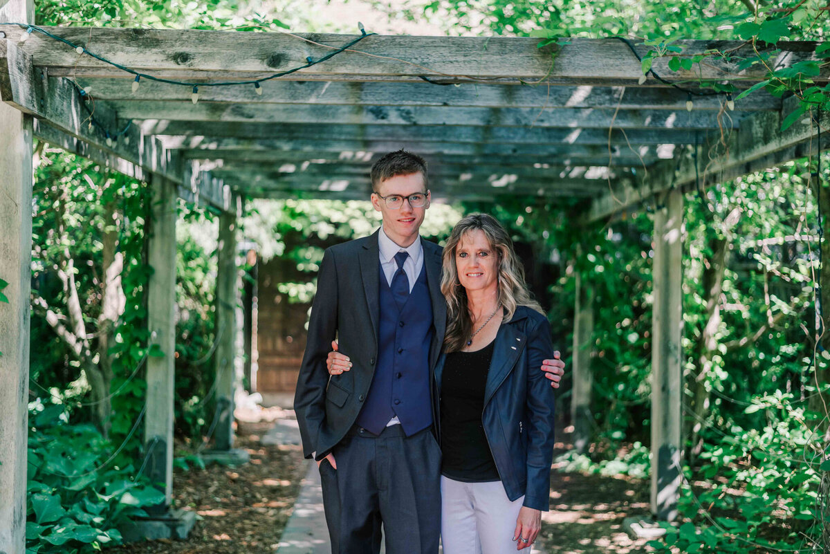 Standing under wooden beams with his mom. 