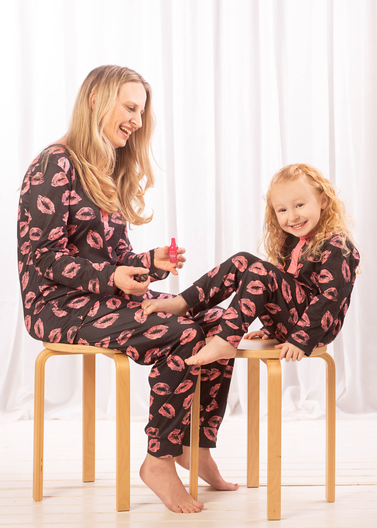 Charming studio portrait of a mother and daughter having pedicures, captured in Overland Park, Kansas. A beautiful option for families seeking emotional and intimate family photography