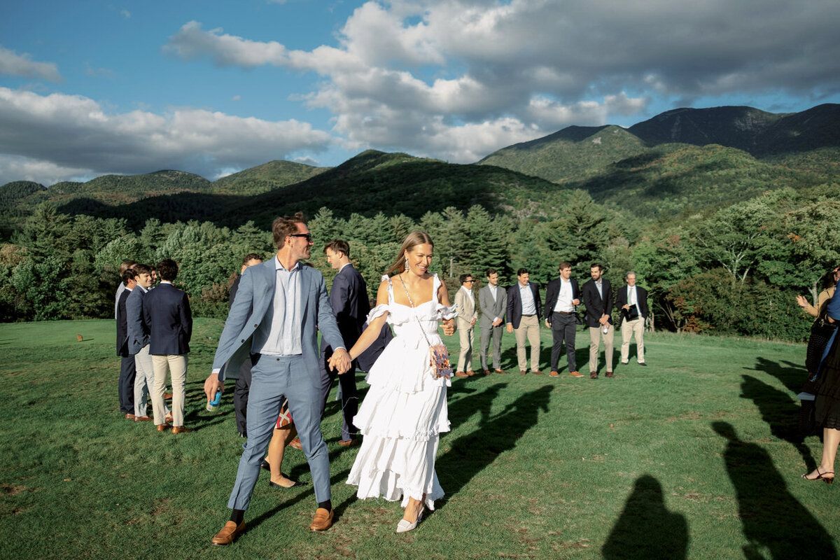 adirondack-mountain-wedding-01-candid-bridal-party-walk-with-scenic-mountain-backdrop-at-adirondack-mountain-wedding-jenny-fu-studio