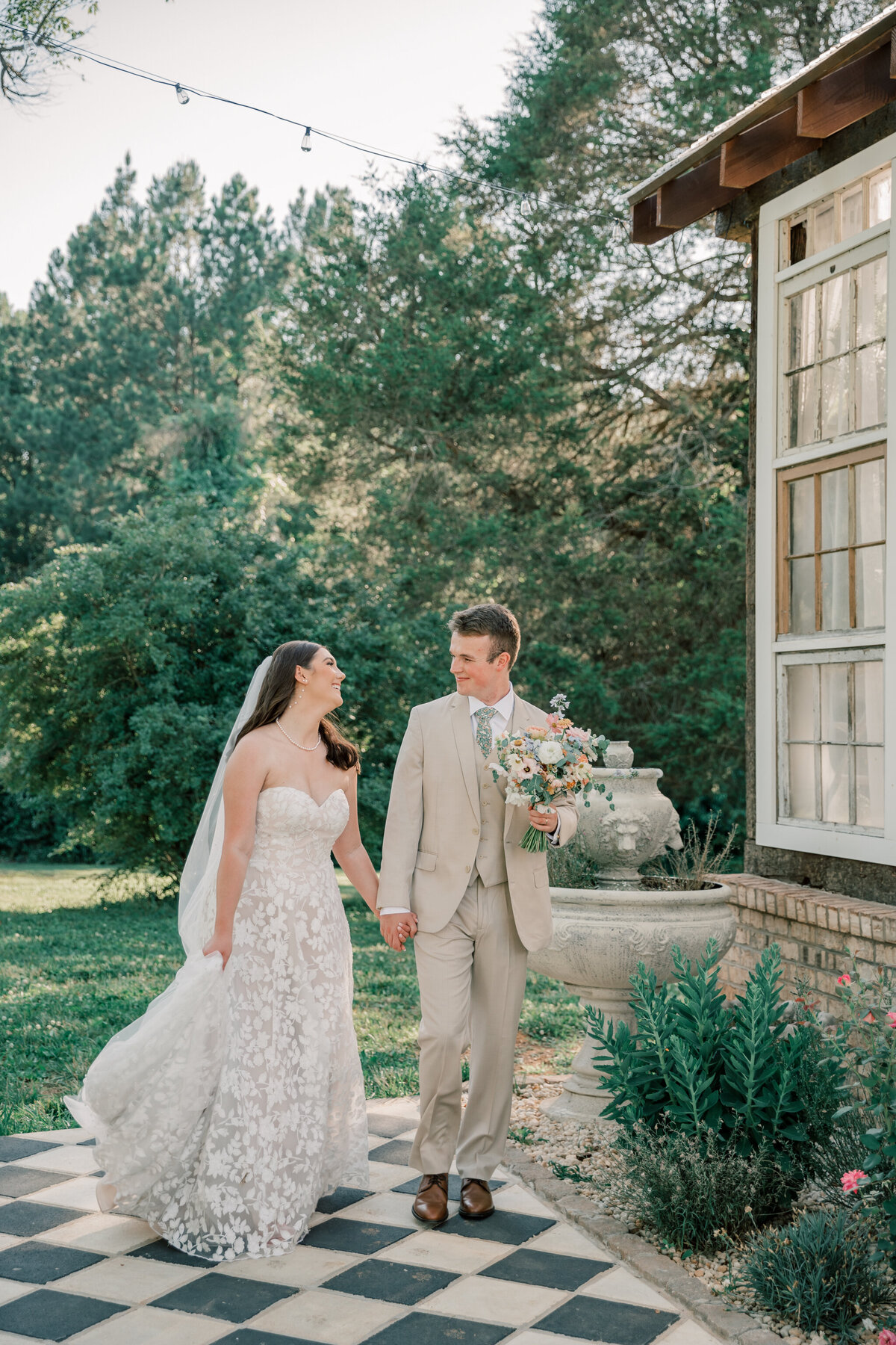 Bride and Groom walking next to the greenhouse at Three Oaks Manor