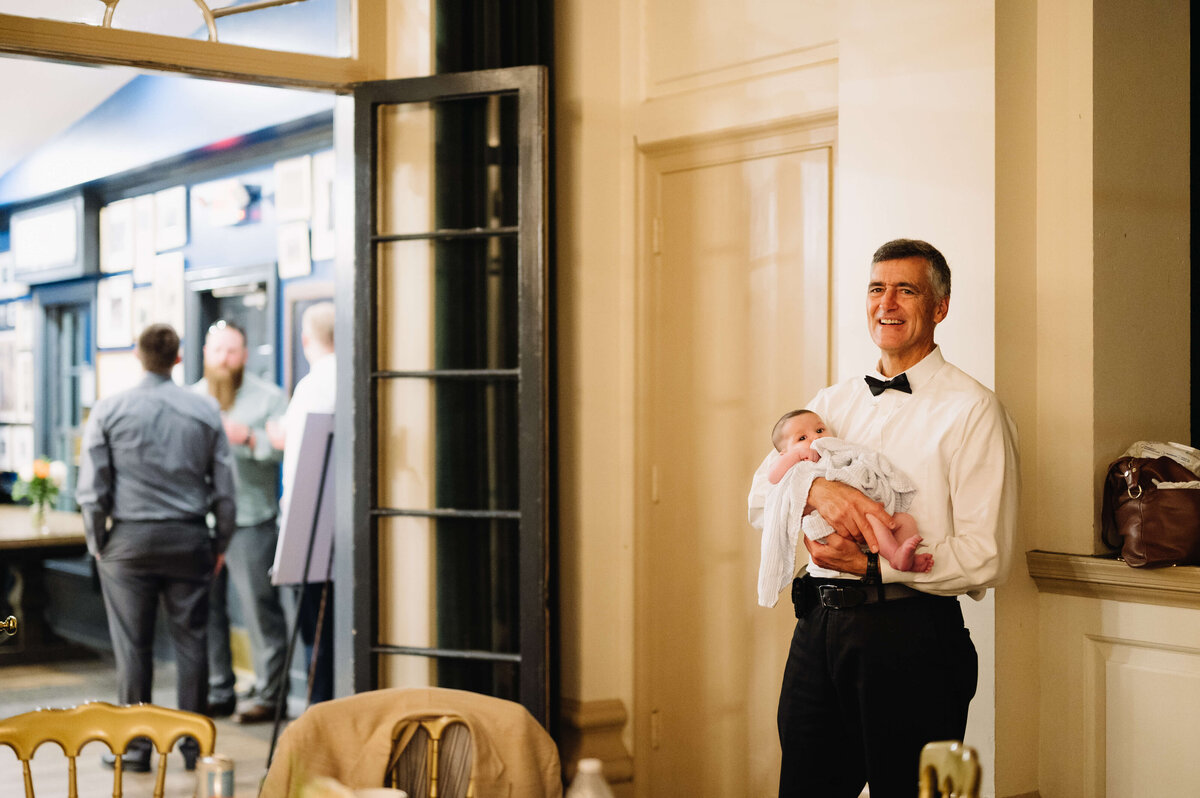 wedding guest holding a baby during the reception captured by Virginia wedding photographer
