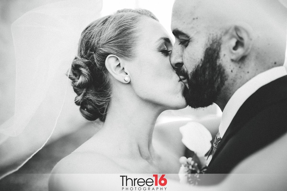 Black & White photo of Bride and Groom sharing a kiss