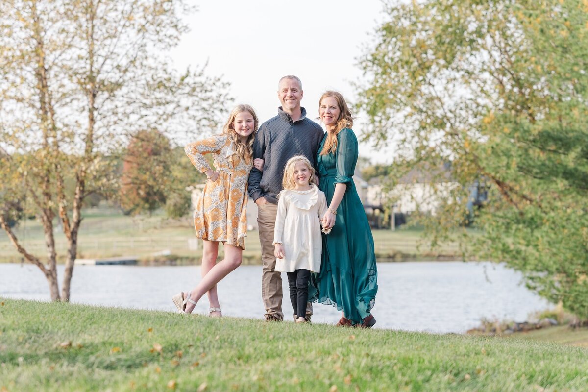 parents posing with their 2 young daughters