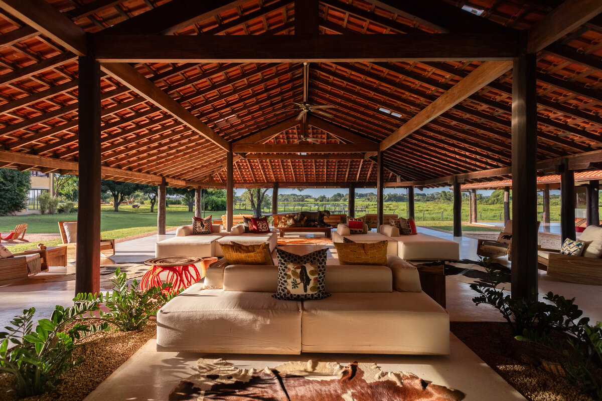 Open-air villa lounge with plush seating and views across tropical gardens, designed for relaxation.