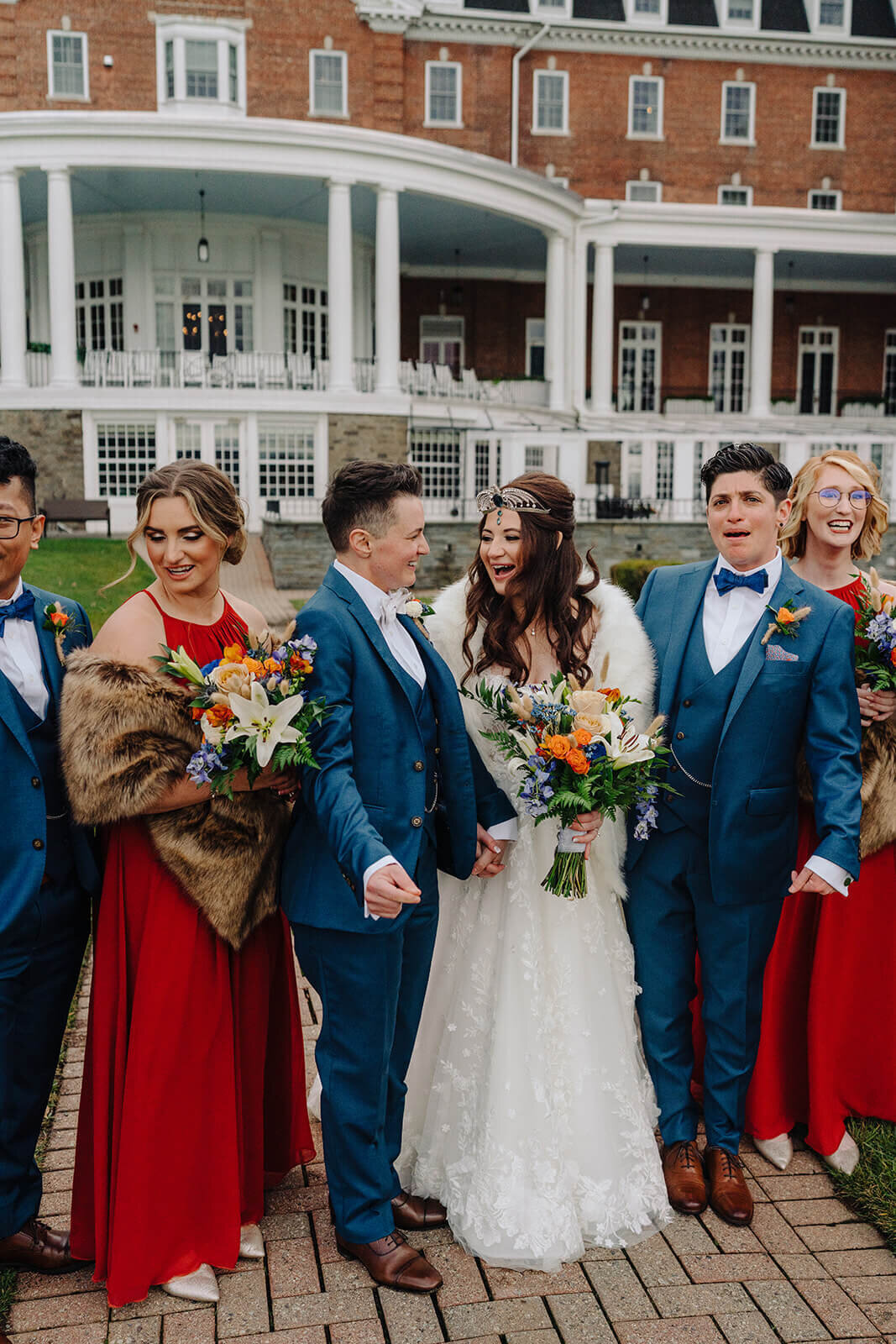 Bridesmaids in red dresses and groomsmen in blue suits for a fall wedding