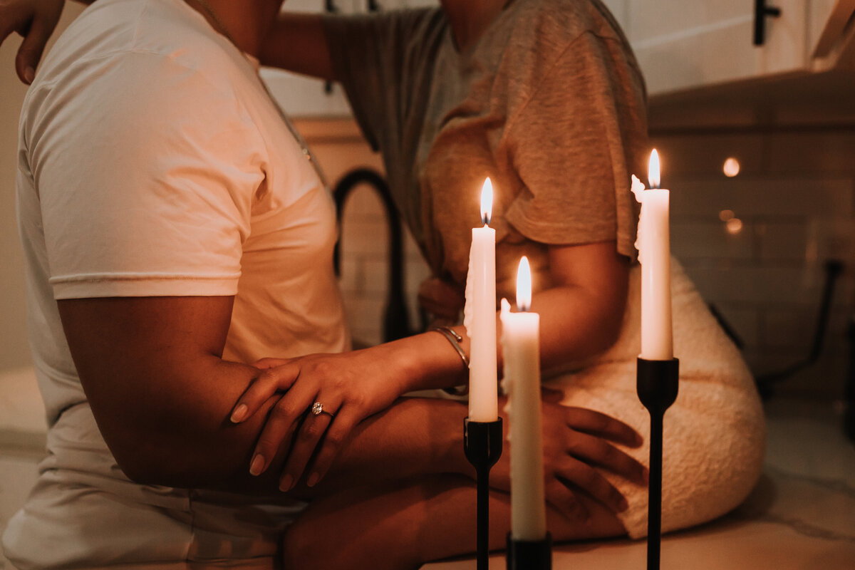 Couple holding each other in front of lit candles