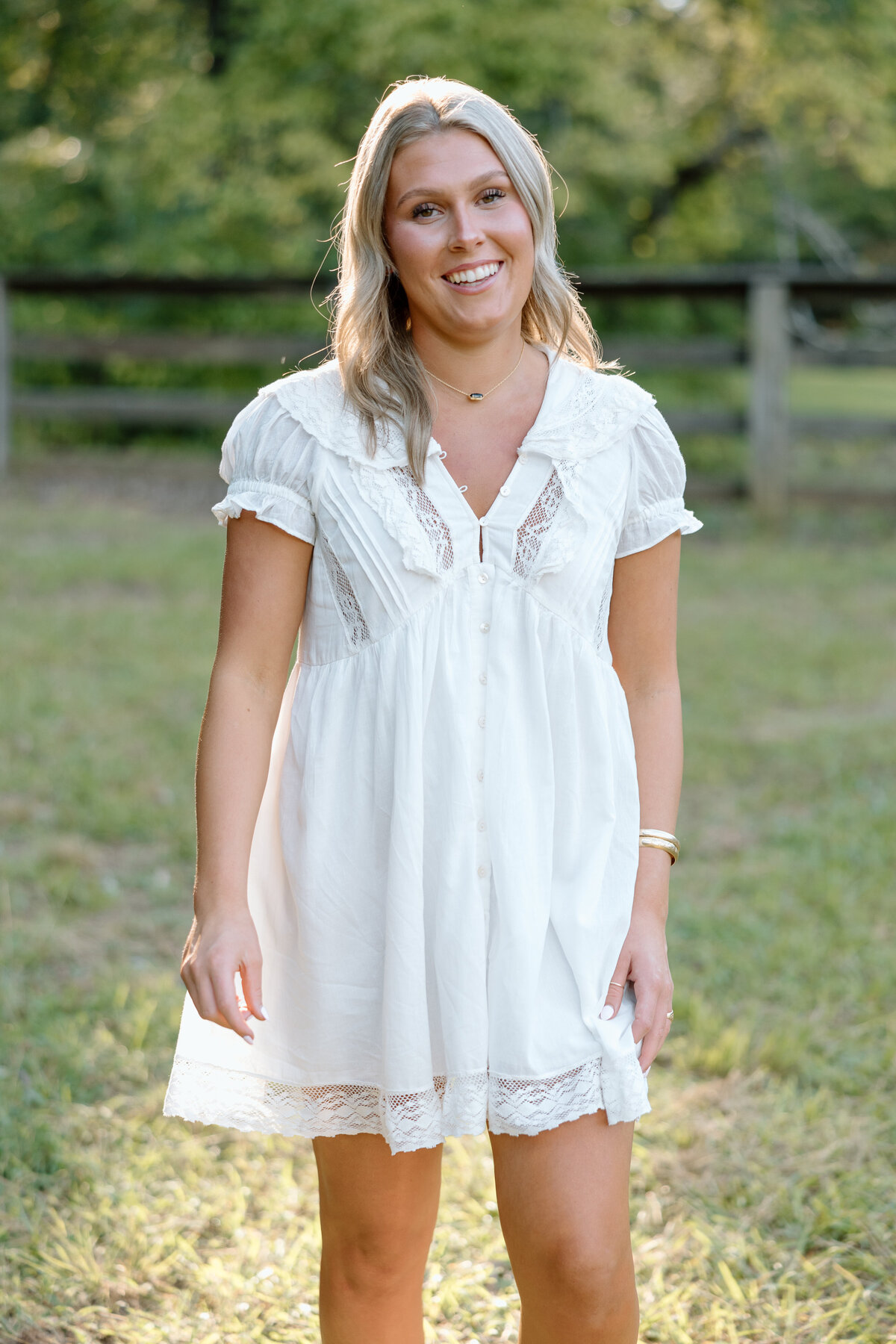 Senior photos on family property; senior laughs at the camera