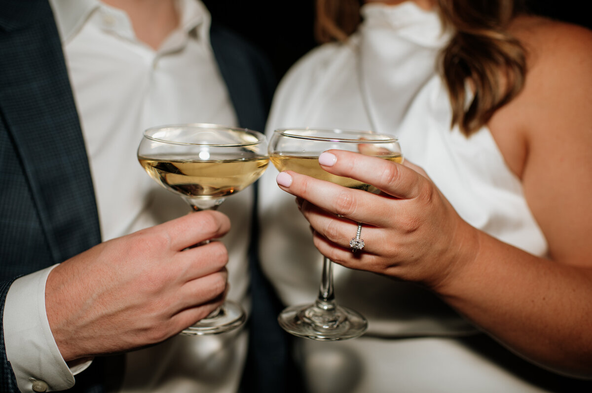 Couple clinking champagne glasses engagement shoot