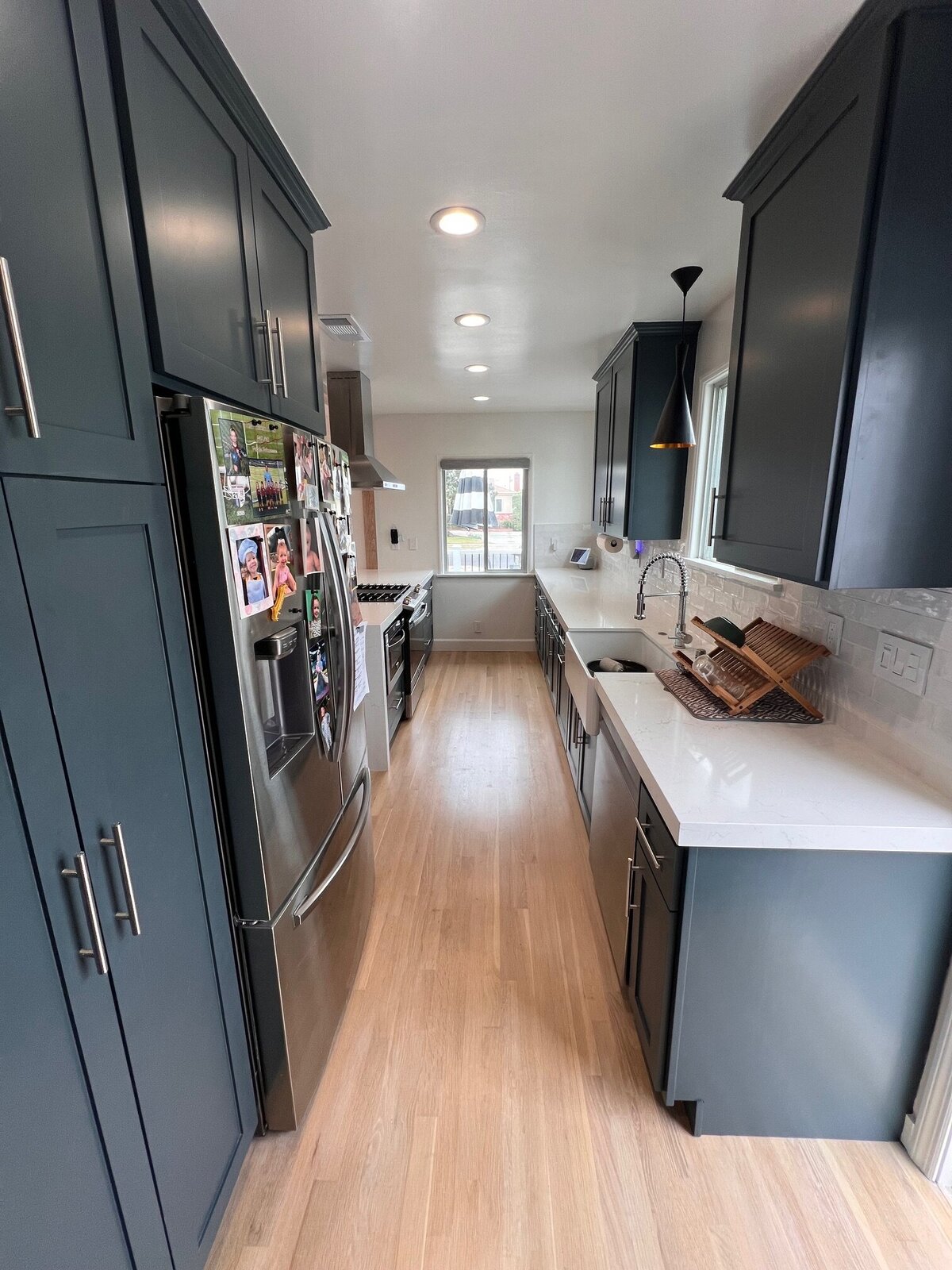 long-galley-kitchen-black-cabinets-white-counters-hardwood-floors