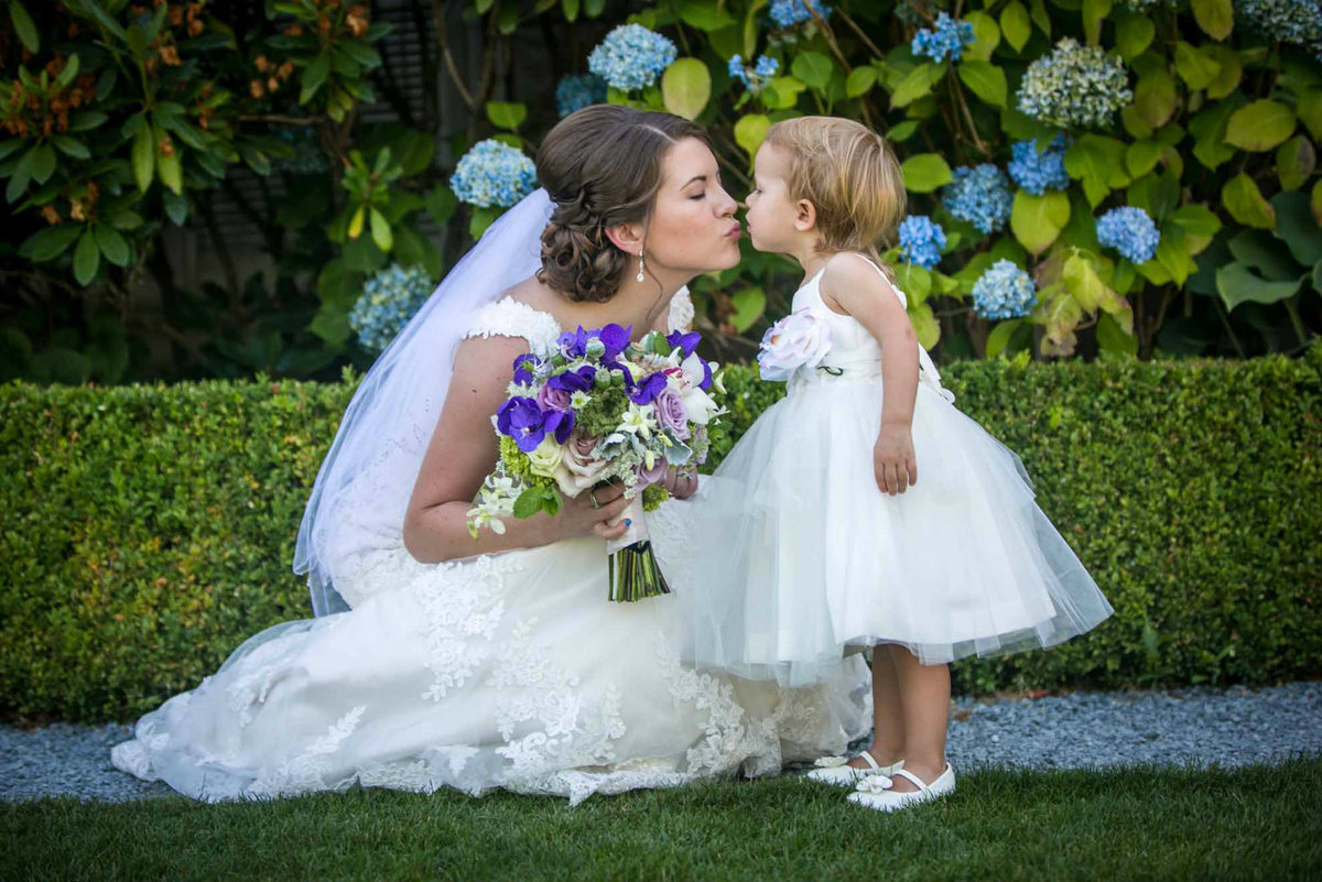 bride and flower girl kissing