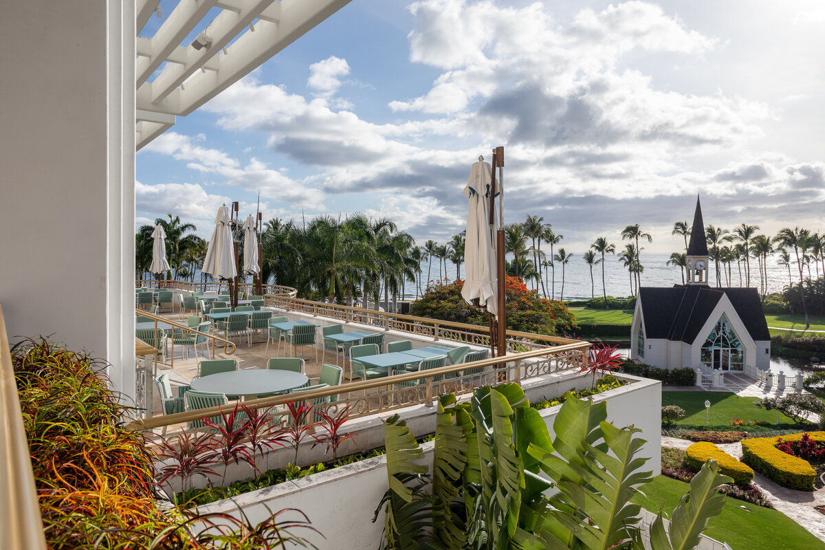 The balcony view of outside tables at the 'Ikena restaurant at the Grand Wailea. A great view of the ocean and resort property can be seen below.