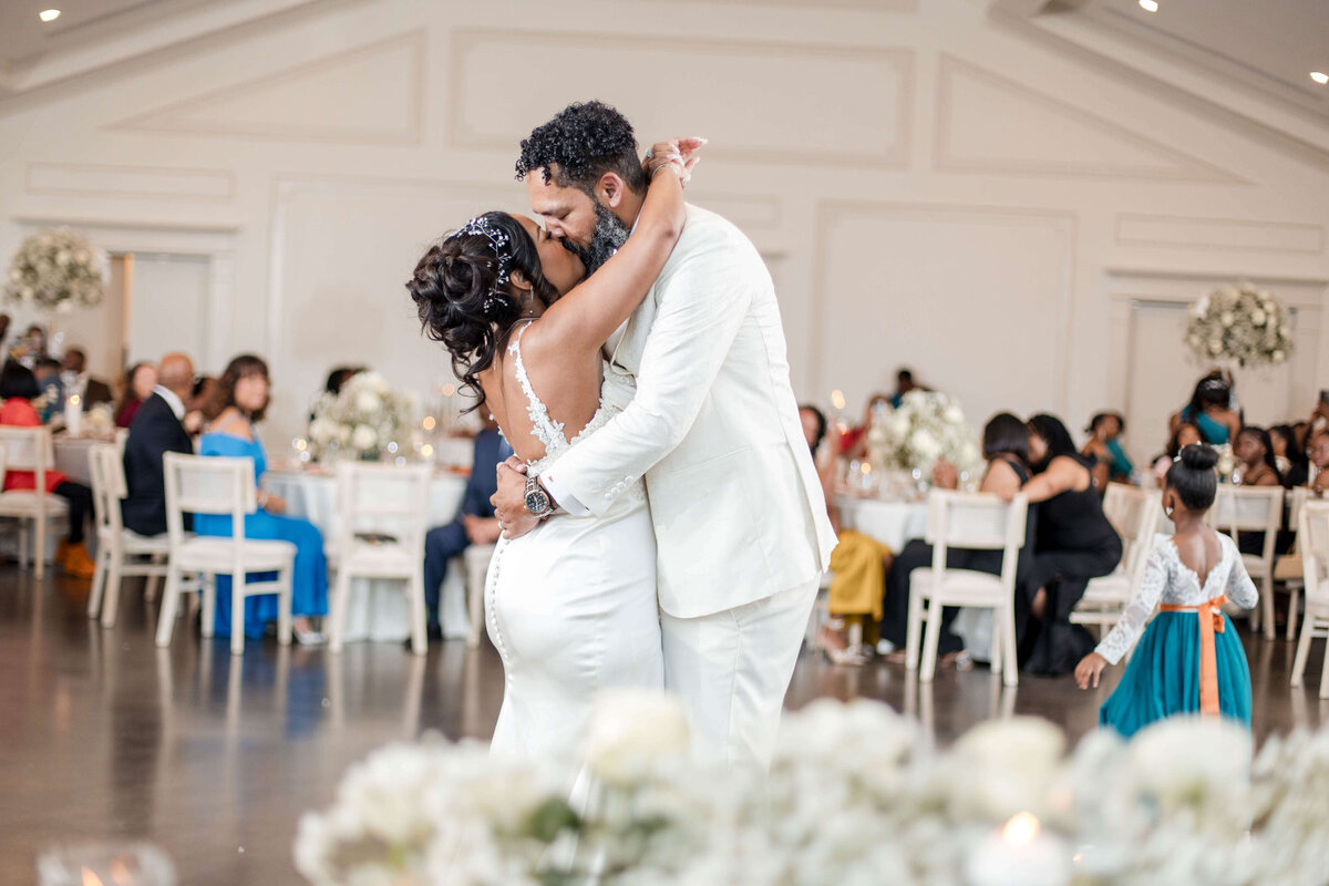 Bride and groom seal their vows with a heartfelt kiss in front of their loved ones.