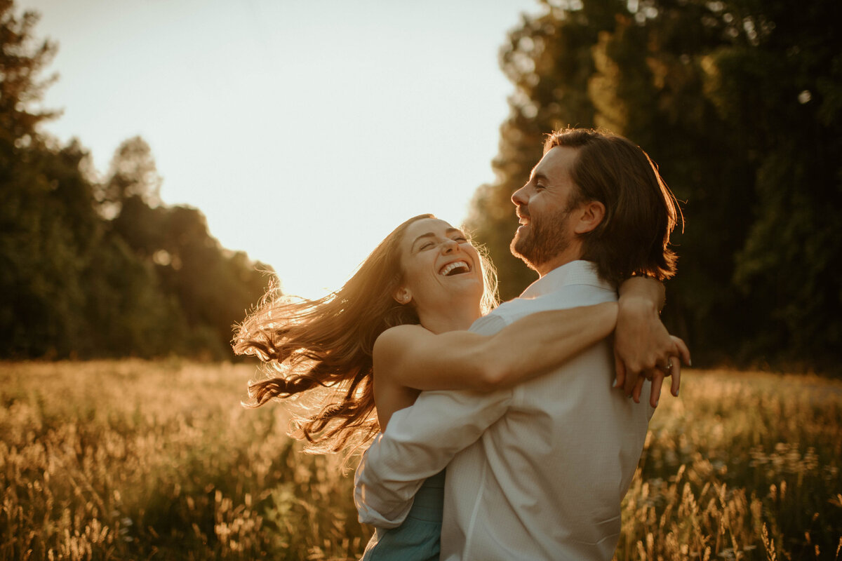 couple frolicking in field at sunset in durham, north carolina