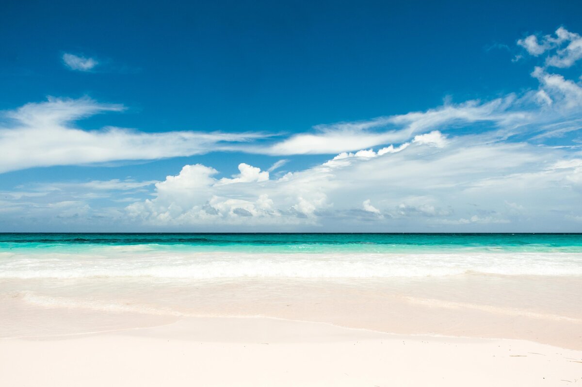 The waves and cirrus clouds mimic one another for this beach scene on Eleuthera. The water is clear and blue green