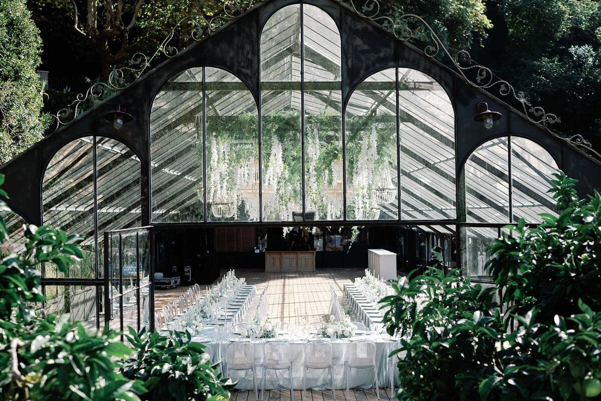 greenhouse wedding reception at quinta da bella vista in sintra, portugal with white flowers cascading from center of structure