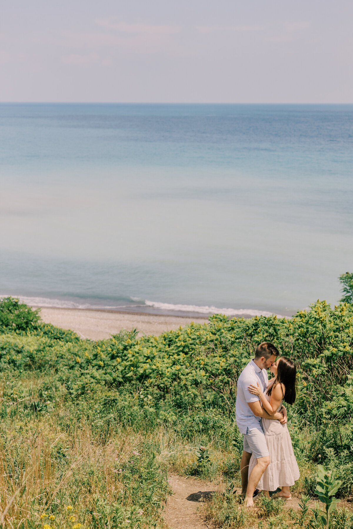 A couple kiss with the beautiful Lake Michigan in the background