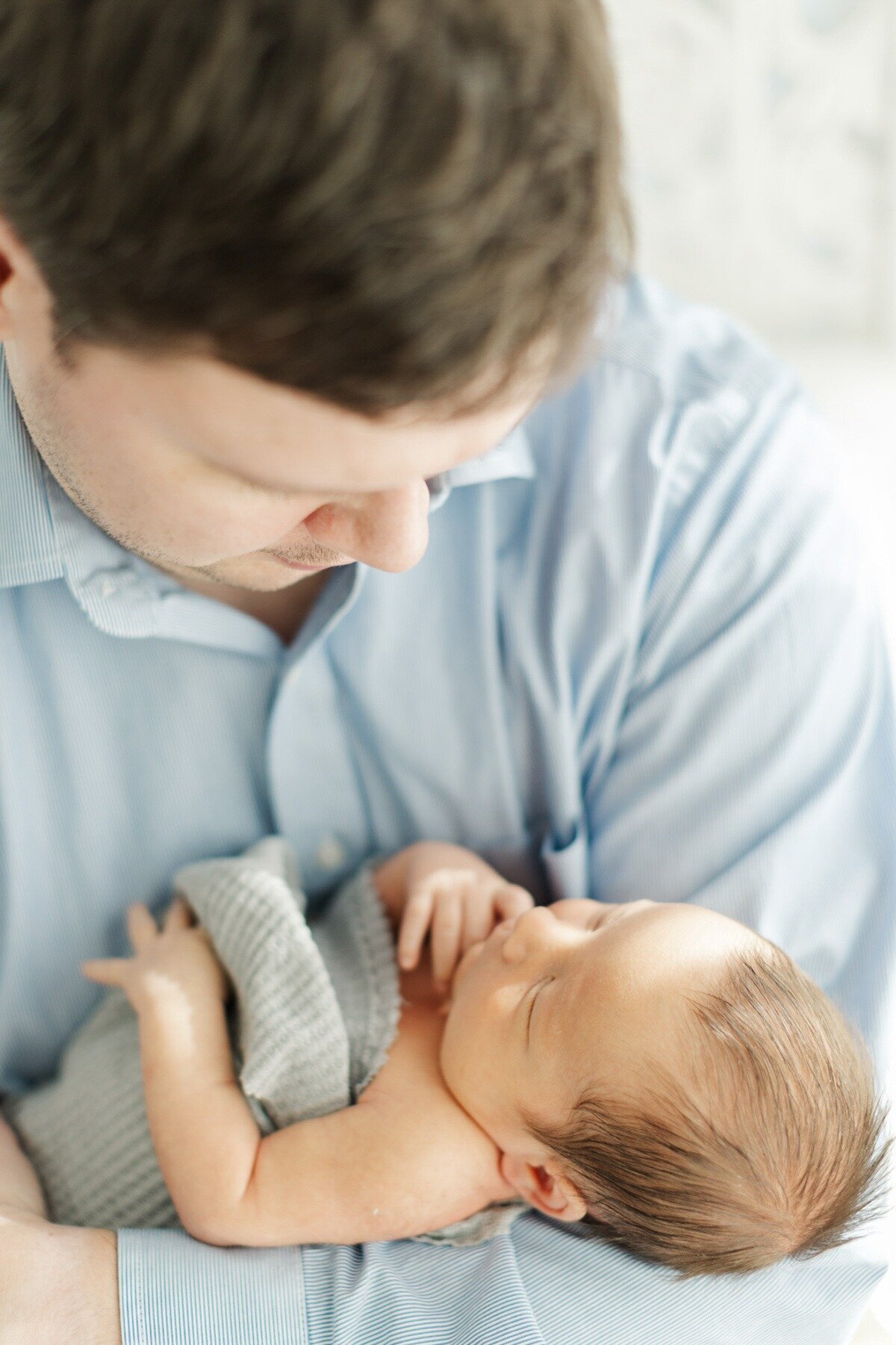 dad holds newborn baby boy for photo session