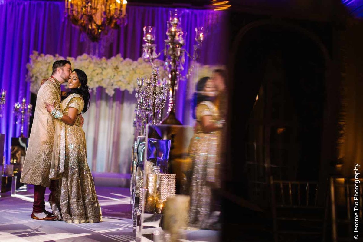 Indian wedding couple in front of grand mirrored wedding arbor and aisle lined with candles and crystal candelabras at Fairmont Olympic wedding Seattle