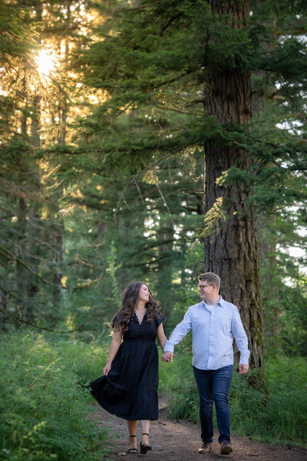 couple walking holding hands in forest of North Bend Washington river park
