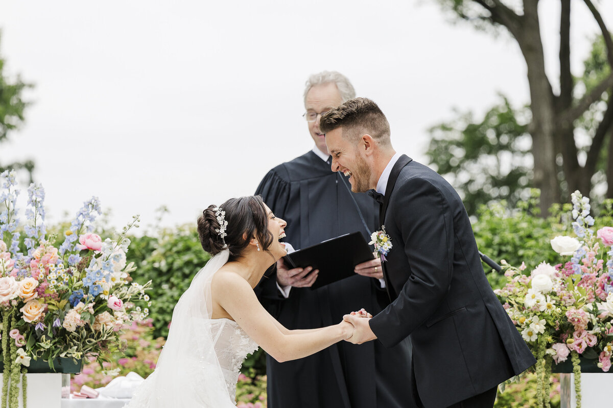 Couple laughs together during their wedding ceremony outdoors at the Briarcliff Manor