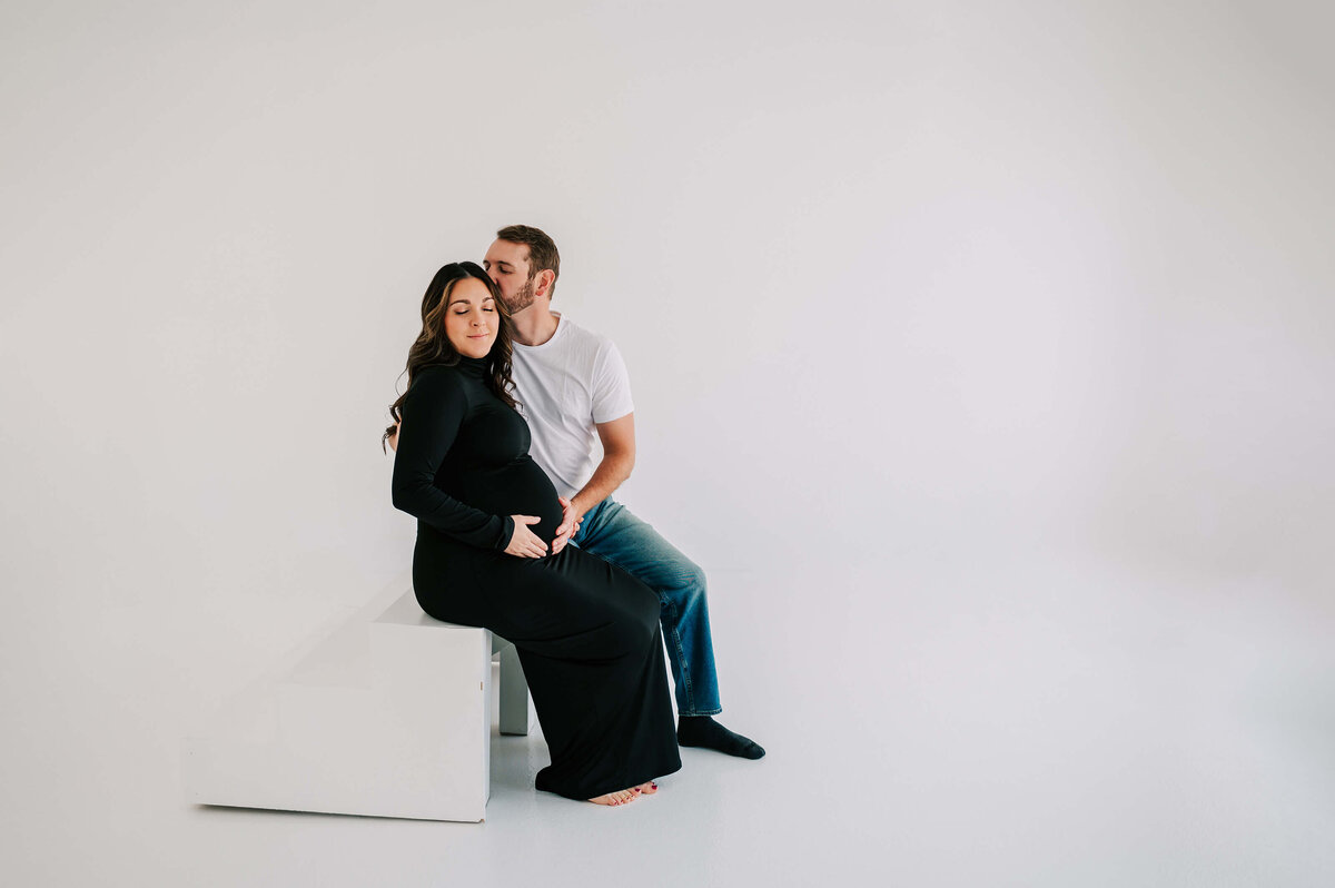 pregnant couple sitting on steps in maternity studio captured by Springfield MO maternity photographer